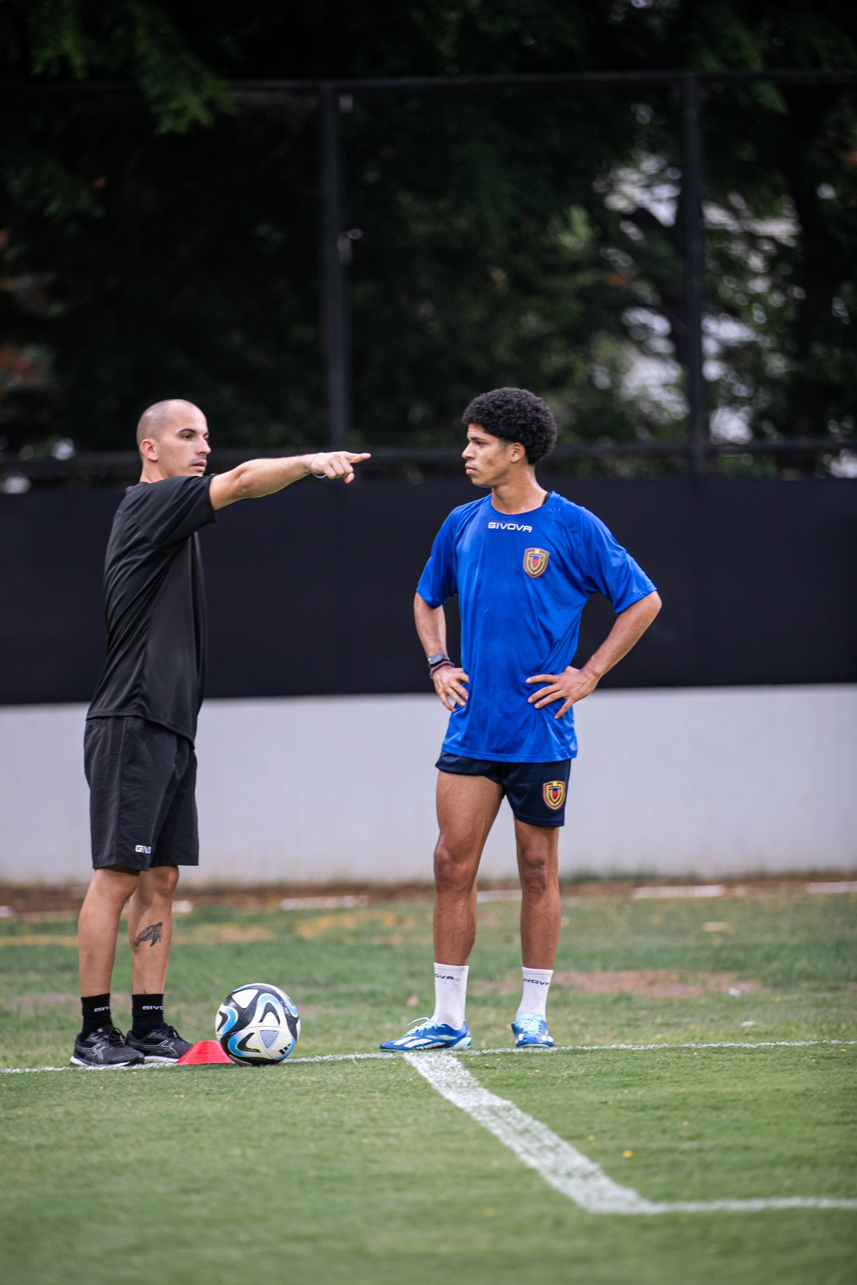 Emiliano Urruchúa trabajando con un jugador en campo de entrenamiento